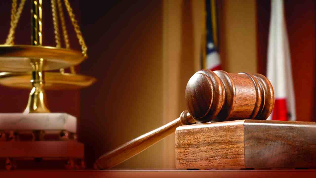Gavel and scales of justice on a wooden desk, symbolizing law and order